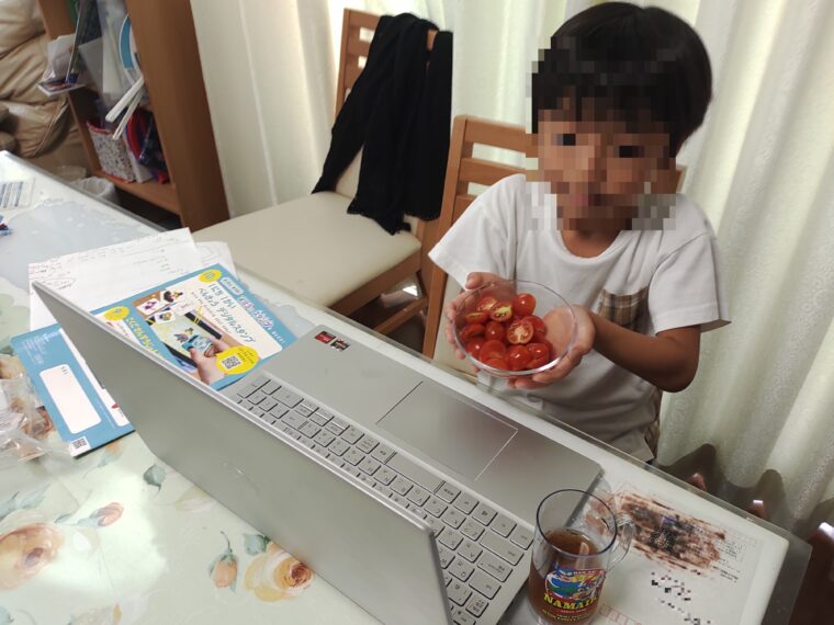 クラウティの先生にトマトを見せる息子